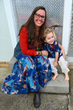 A woman and a young child sitting together while wearing a Tallows Shirt Wanderlust Navy and Wanderlust Navy Pants.