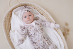 Baby in an Aster & Oak Zip Romper Butterfly Fields and hat.