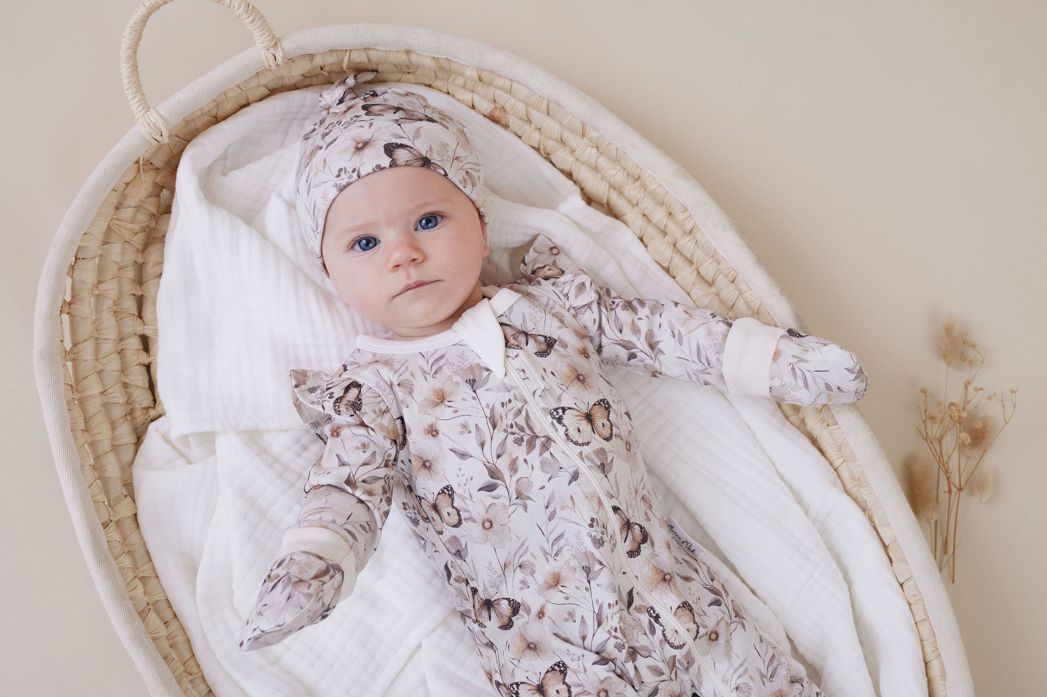 Baby in an Aster & Oak Zip Romper Butterfly Fields and hat.