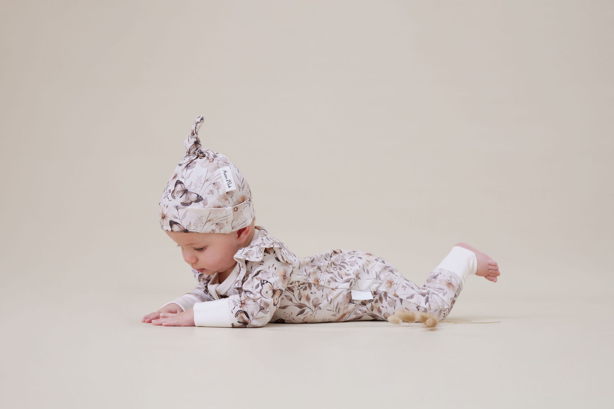 Baby in an Aster & Oak Zip Romper Butterfly Fields and hat.