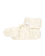 cream knitted baby booties with pom-pom on a white background
