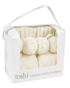 Toshi Cream organic baby booties in a white box on a white background.