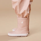 Crywolf Rain Boots Dusty Pink worn with beige pants on a beige background