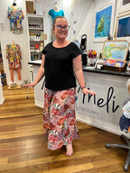 A woman wearing a black short-sleeve top and a long, wide Byron Pant Agave Pinks.