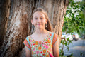 Young girl in a MilaMeli Jesse Frill Dress - Festival Garden standing next to a tree