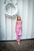 Lifestyle shot featuring a child in a bohemian-style sleeveless jumpsuit in a Lilac haze print, a vibrant shades of magenta, pink, and cream, highlighting the soft, earthy color palette.