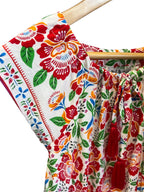 Floral dress featuring Fiesta Bloom print, a white base with a vibrant floral pattern in red, orange, green, and blue.