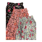 Three pairs of women's tiered ruffle shorts with floral prints, stacked diagonally. The top is Maeve Maxi Skirt Indigo Wildflower and the middle is the Maeve Maxi Skirt blush pink print, the bottom is Maeve Maxi Skirt Indigo Wildflower Print.