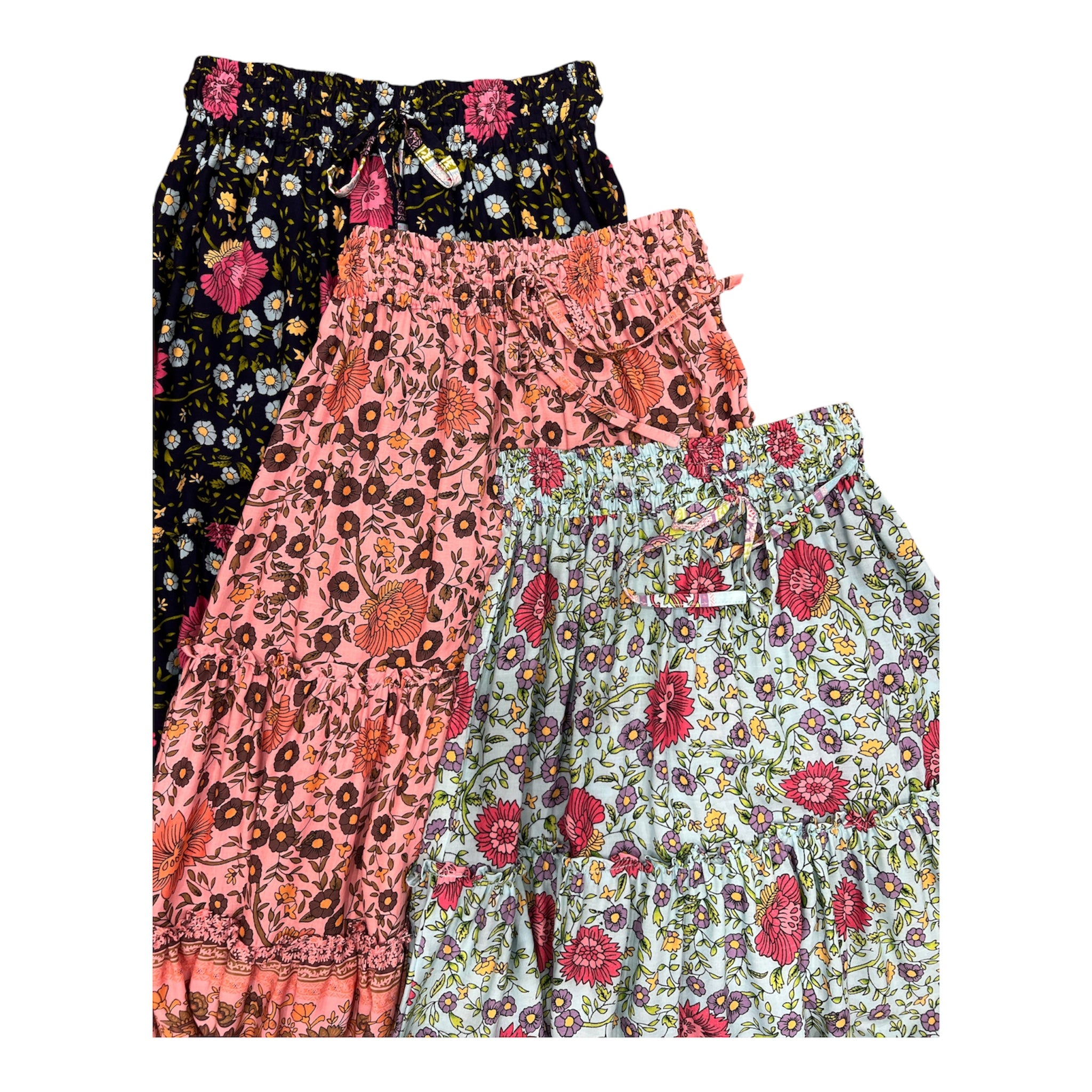 Three pairs of women's tiered ruffle shorts with floral prints, stacked diagonally. The top pair is black with pink and yellow flowers; the middle is pink with brown and orange floral motifs; the bottom is light blue with red and yellow flowers.