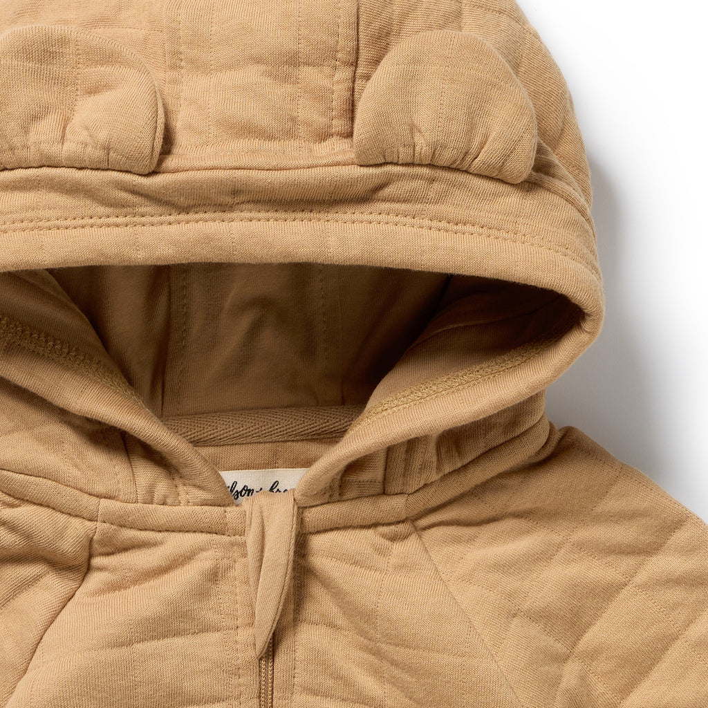 Close-up of Wilson & Frenchy Honey Fawn Organic Quilted Jacket, a Beighe quilted with bear ears.
