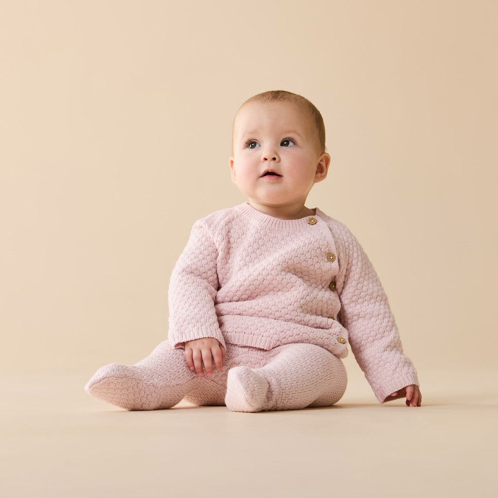 Baby wearing a Wilson & Frenchy Organic Knitted Bubble Pant Marshmallow Pink footed.