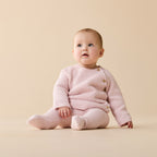 Baby wearing a Wilson & Frenchy Organic Knitted Bubble Pant Marshmallow Pink footed.