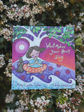 Book titled 'What Makes Your Heart Sing' by Amy Louise Tucker and Lindy Longhurst, surrounded by flowers.