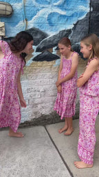Three young girls wearing Lilac haze print, bohemian-style in vibrant shades of magenta, pink, and cream.